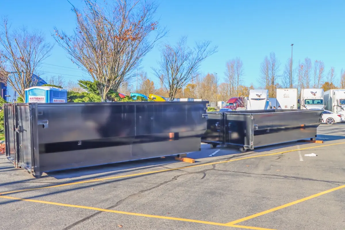 Professional dumpster rental service with roll-off container on residential driveway in Buxton